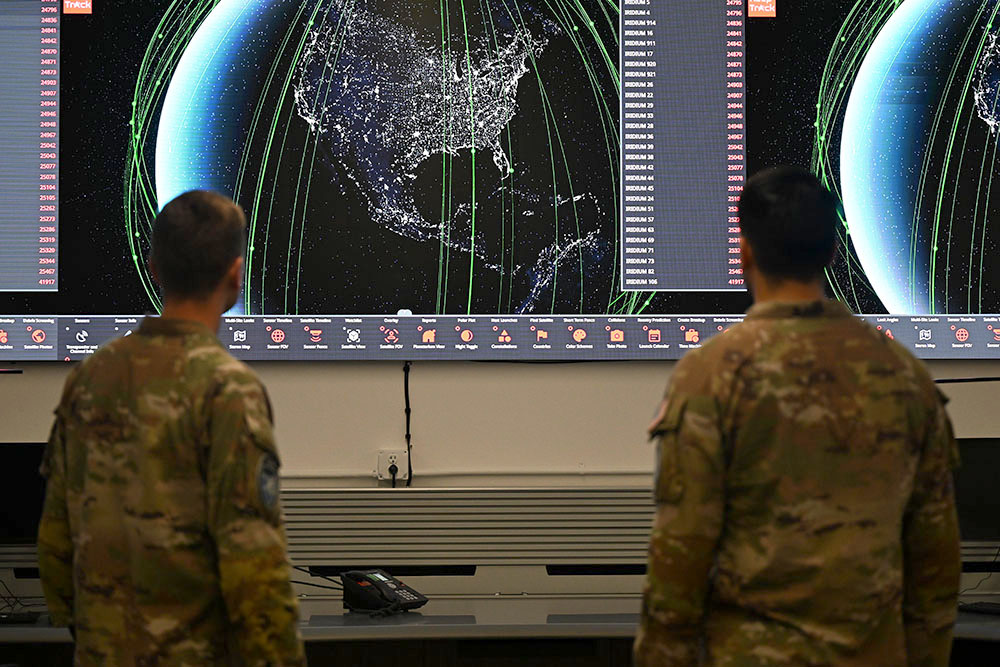 U.S. Space Force Guardian working beside a large ground communications antenna